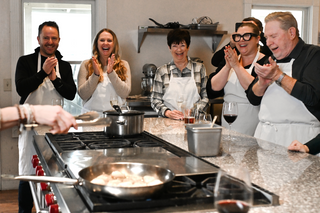 Group of guest at The Recipe clapping during a cooking class.